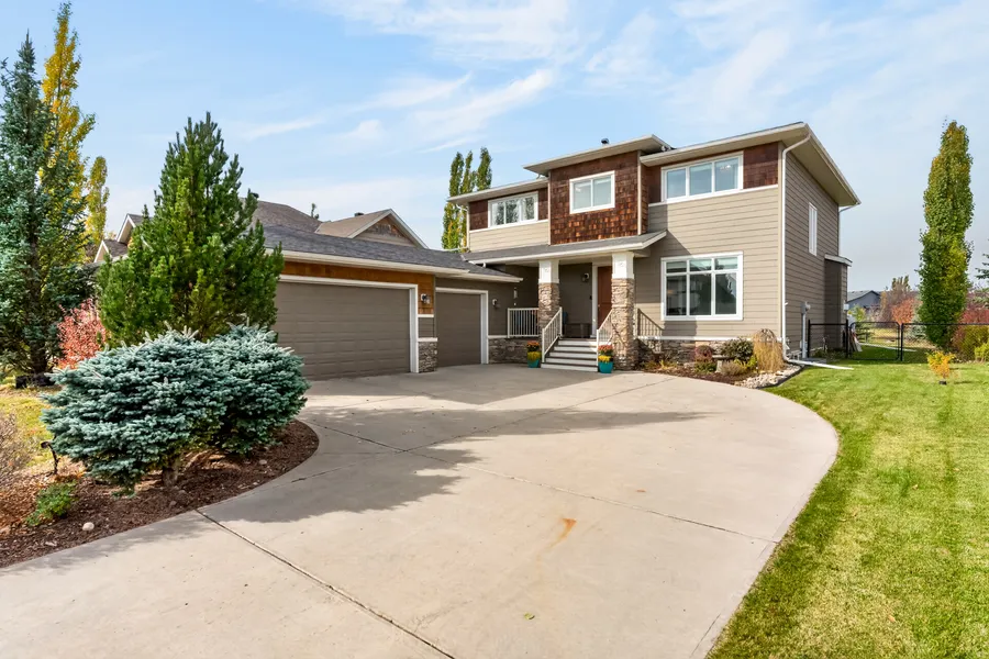 Front elevation, curved drive and mature spruce