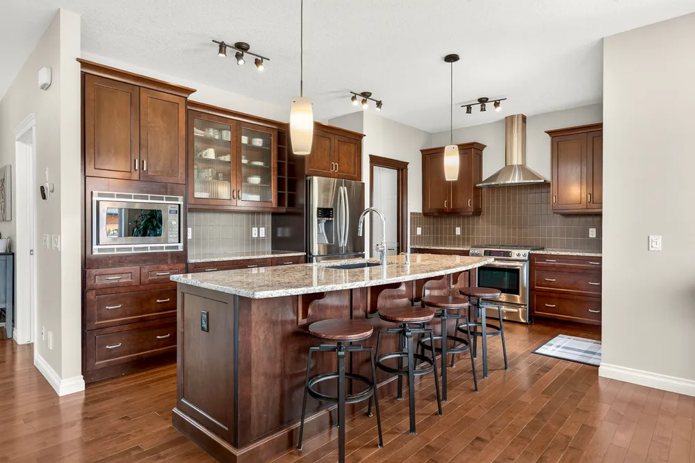 Chef-inspired kitchen with granite counters, an expansive centre island and stainless appliances.