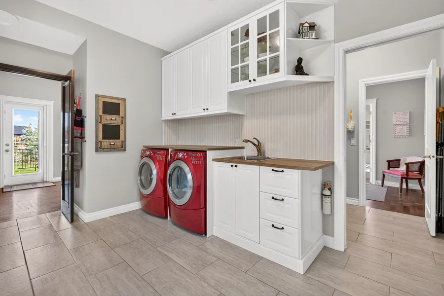 Laundry room with sink and upper cabinets