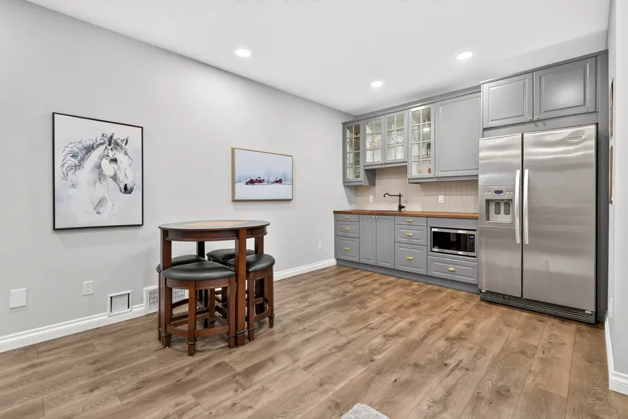 Wet bar with butcher-block counter and stainless fridge
